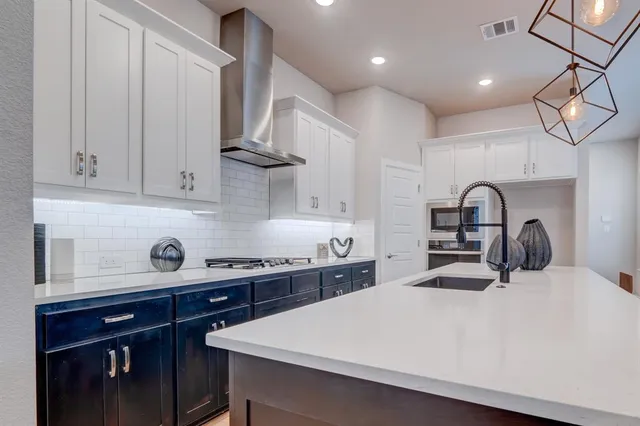 a kitchen with a sink a stove and cabinets