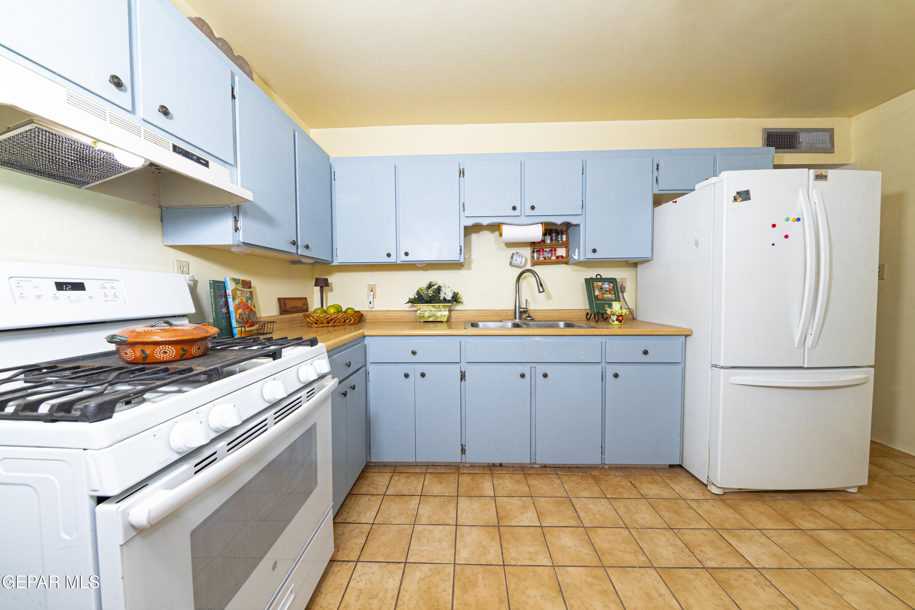 3329 Harrison Avenue El Paso, TX 79930 - Photo 13 of 38 a kitchen with a refrigerator a stove a sink and cabinets