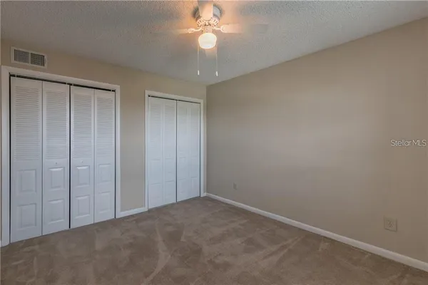an empty room with a chandelier fan