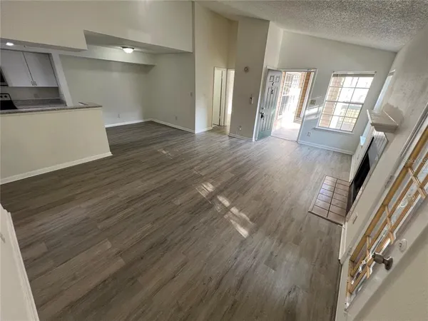 a view of entryway and kitchen with wooden floor