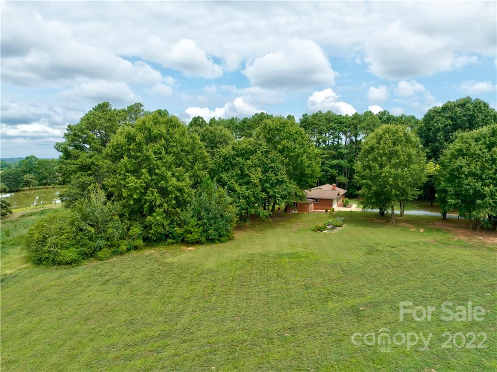6118 South Rocky River Road Monroe, NC 28112 - Photo 1 of 33 a backyard of a house with lots of green space and garden