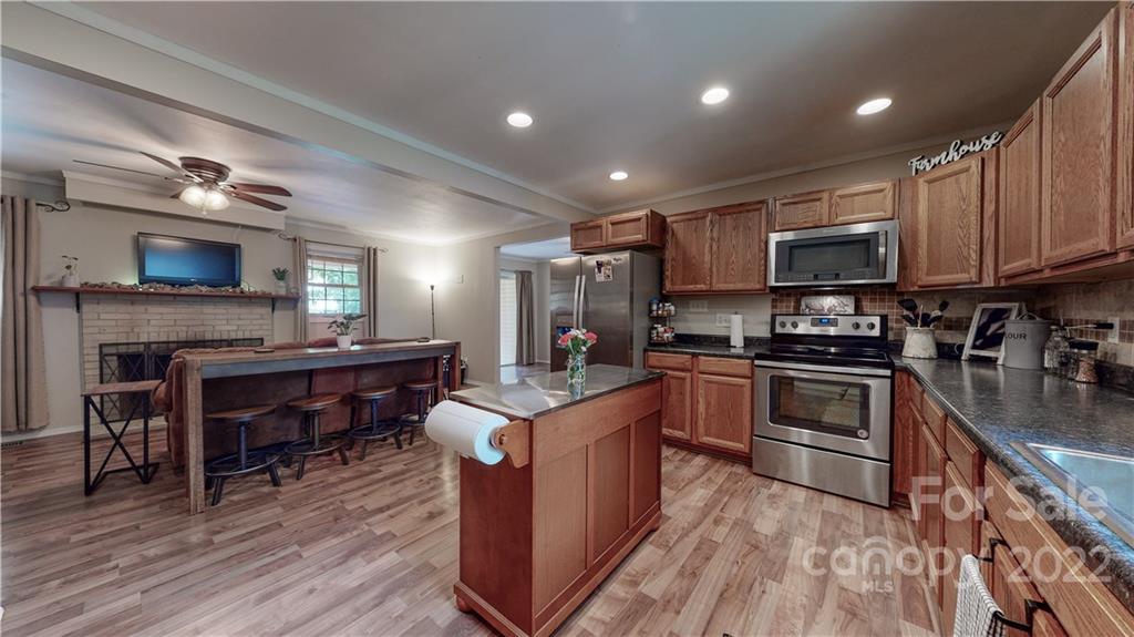 6118 South Rocky River Road Monroe, NC 28112 - Photo 11 of 33 a kitchen with kitchen island granite countertop stainless steel appliances and wooden cabinets