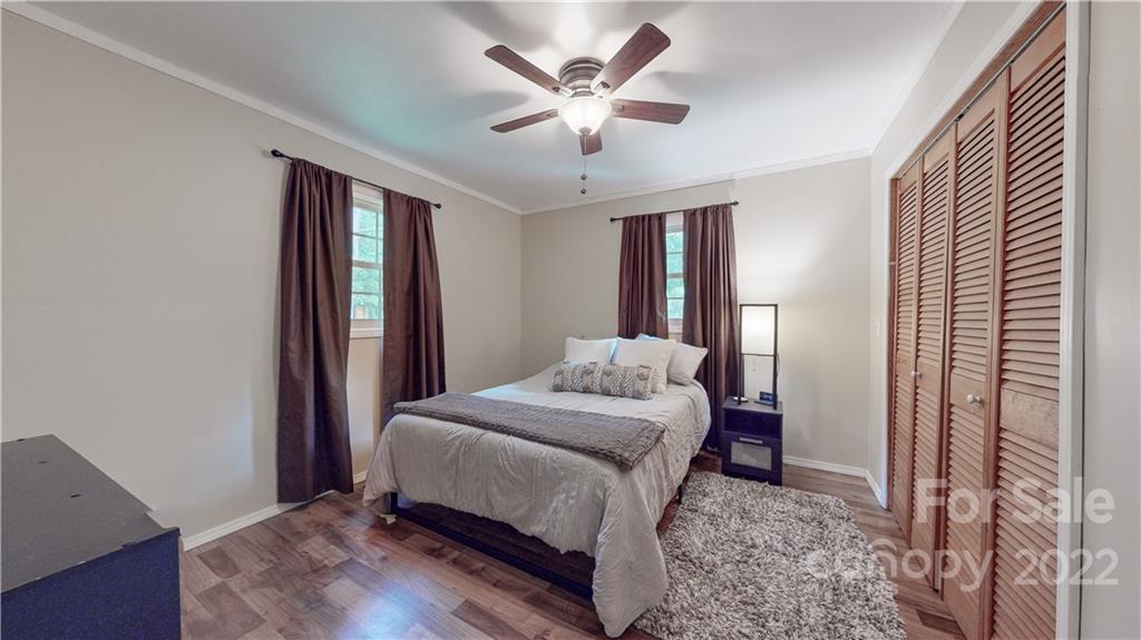 6118 South Rocky River Road Monroe, NC 28112 - Photo 15 of 33 a bedroom with a large bed and a chandelier