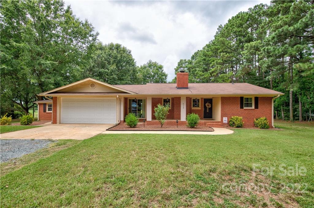 6118 South Rocky River Road Monroe, NC 28112 - Photo 33 of 33 a front view of a house with a garden and trees