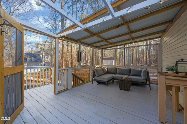 a living room with furniture a wooden floor and a large window
