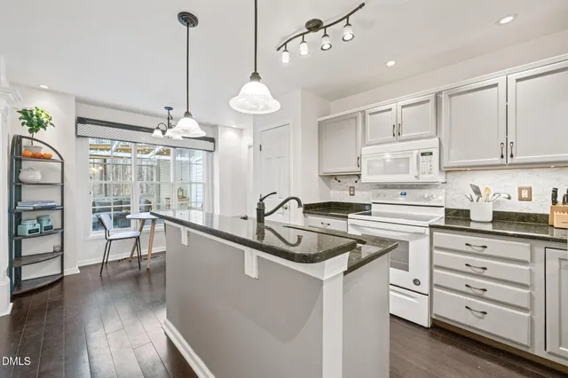 a kitchen that has a lot of cabinets and wooden floor