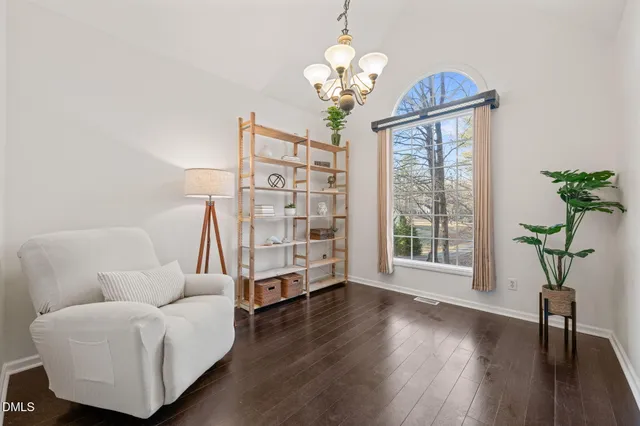 a living room with furniture a chandelier and a window