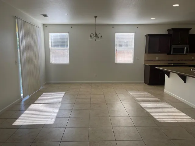 a kitchen with kitchen island granite countertop a refrigerator a stove a sink and a counter