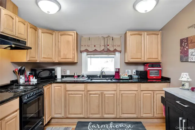 a kitchen with stainless steel appliances granite countertop a stove a sink and a microwave