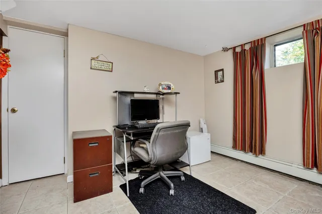 a view of a workspace with furniture and a window