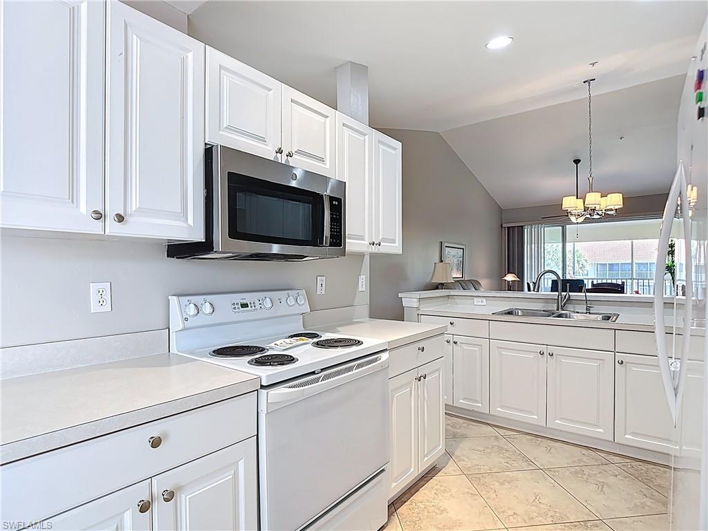 4970 Deerfield Way, Unit F203 Naples, FL 34110 - Photo 13 of 47 a kitchen with cabinets appliances a sink and a counter top space