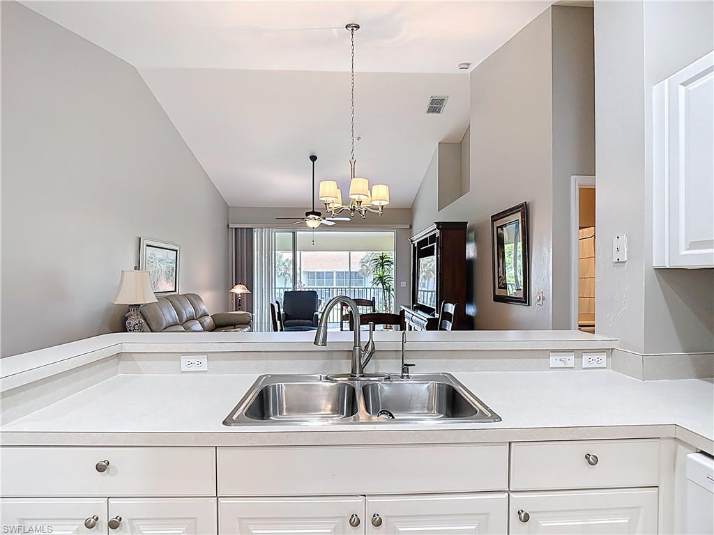4970 Deerfield Way, Unit F203 Naples, FL 34110 - Photo 15 of 47 a kitchen with a sink and chandelier