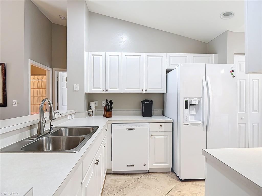 4970 Deerfield Way, Unit F203 Naples, FL 34110 - Photo 17 of 47 a kitchen with a white stove a sink and refrigerator