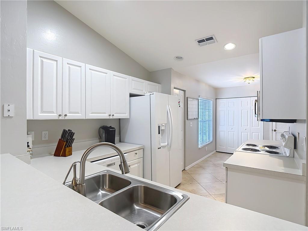 4970 Deerfield Way, Unit F203 Naples, FL 34110 - Photo 18 of 47 a kitchen with a refrigerator sink and cabinets