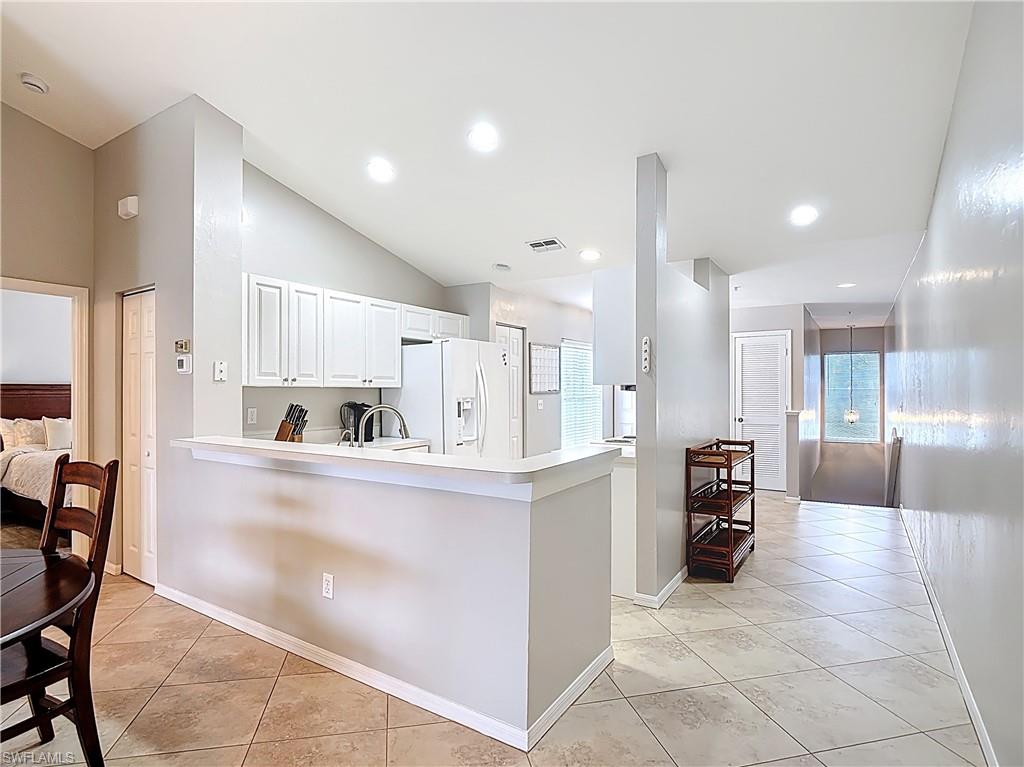 4970 Deerfield Way, Unit F203 Naples, FL 34110 - Photo 22 of 47 a large white kitchen with lots of counter space and stainless steel appliances