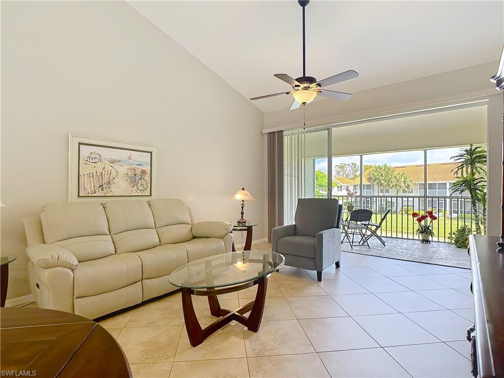 4970 Deerfield Way, Unit F203 Naples, FL 34110 - Photo 23 of 47 a living room with furniture and a chandelier