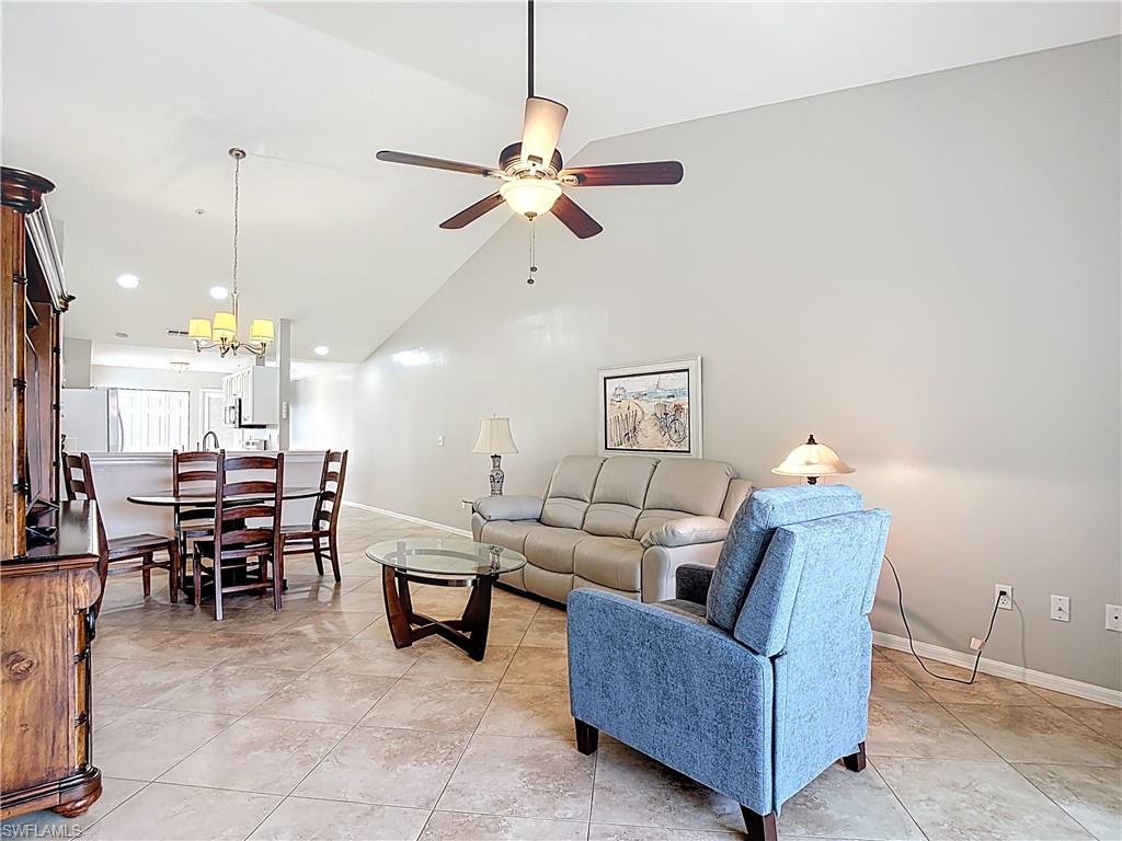 4970 Deerfield Way, Unit F203 Naples, FL 34110 - Photo 27 of 47 a living room with furniture a dining table and a piano