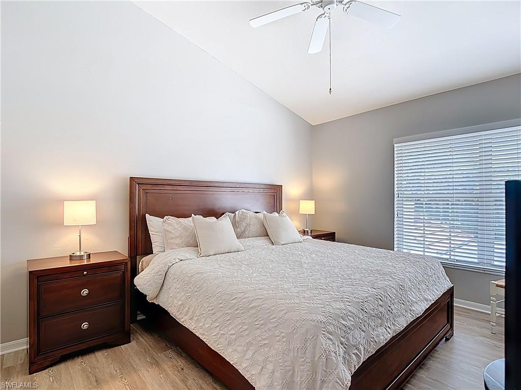 4970 Deerfield Way, Unit F203 Naples, FL 34110 - Photo 28 of 47 a bedroom with a bed and a lamp