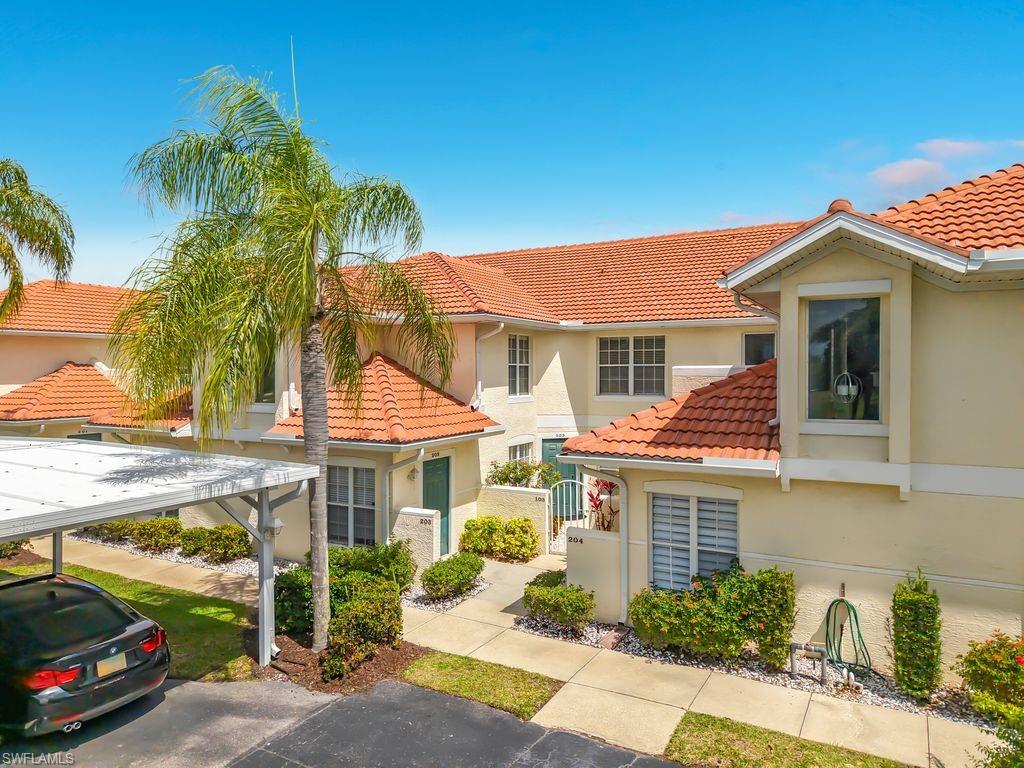 4970 Deerfield Way, Unit F203 Naples, FL 34110 - Photo 3 of 47 a view of a car park in front of house