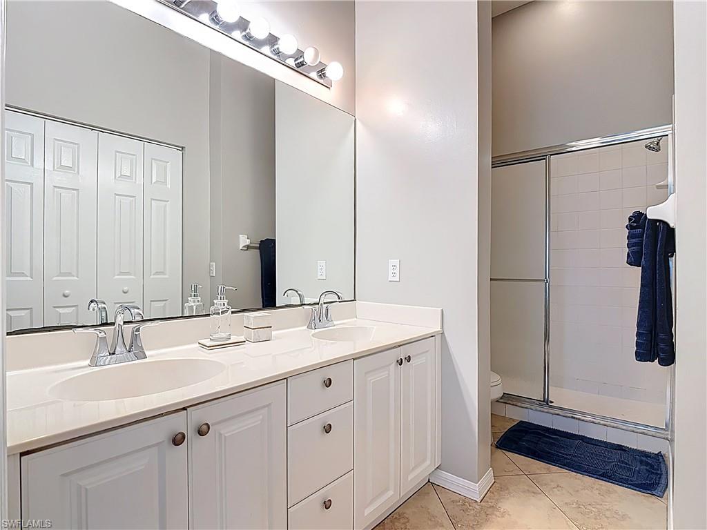 4970 Deerfield Way, Unit F203 Naples, FL 34110 - Photo 36 of 47 a bathroom with a sink and a mirror