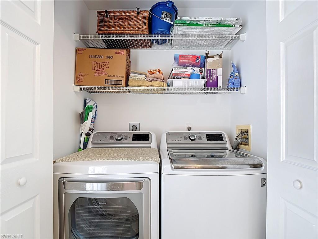 4970 Deerfield Way, Unit F203 Naples, FL 34110 - Photo 41 of 47 a view of washer and dryer with kitchen in the background