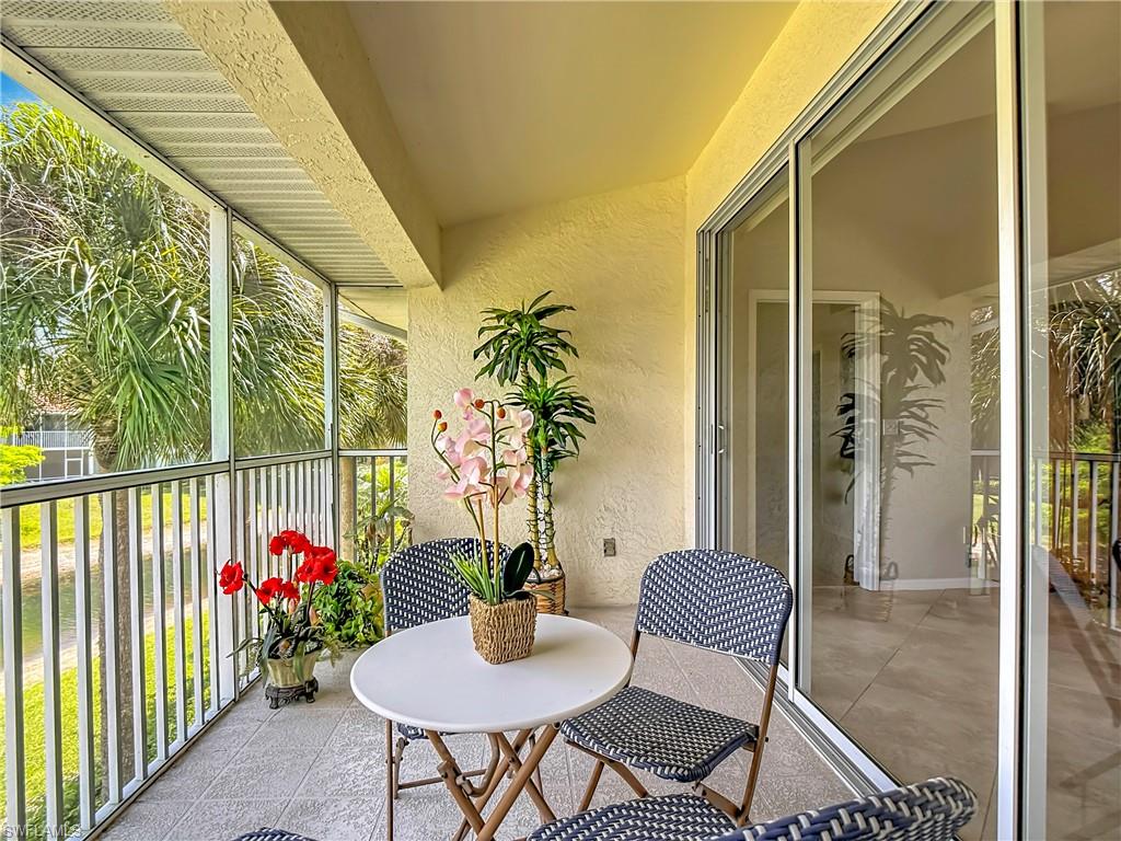 4970 Deerfield Way, Unit F203 Naples, FL 34110 - Photo 46 of 47 a balcony with table and chairs