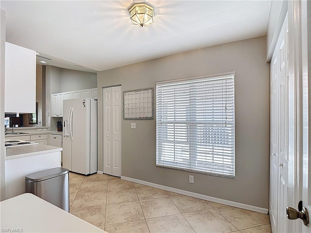 4970 Deerfield Way, Unit F203 Naples, FL 34110 - Photo 9 of 47 a view of a kitchen with refrigerator and window