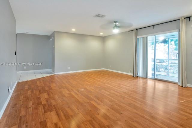 22765 Southwest 66th Avenue, Unit 205 Boca Raton, FL 33428 - Photo 3 of 24 a view of empty room with wooden floor and fan