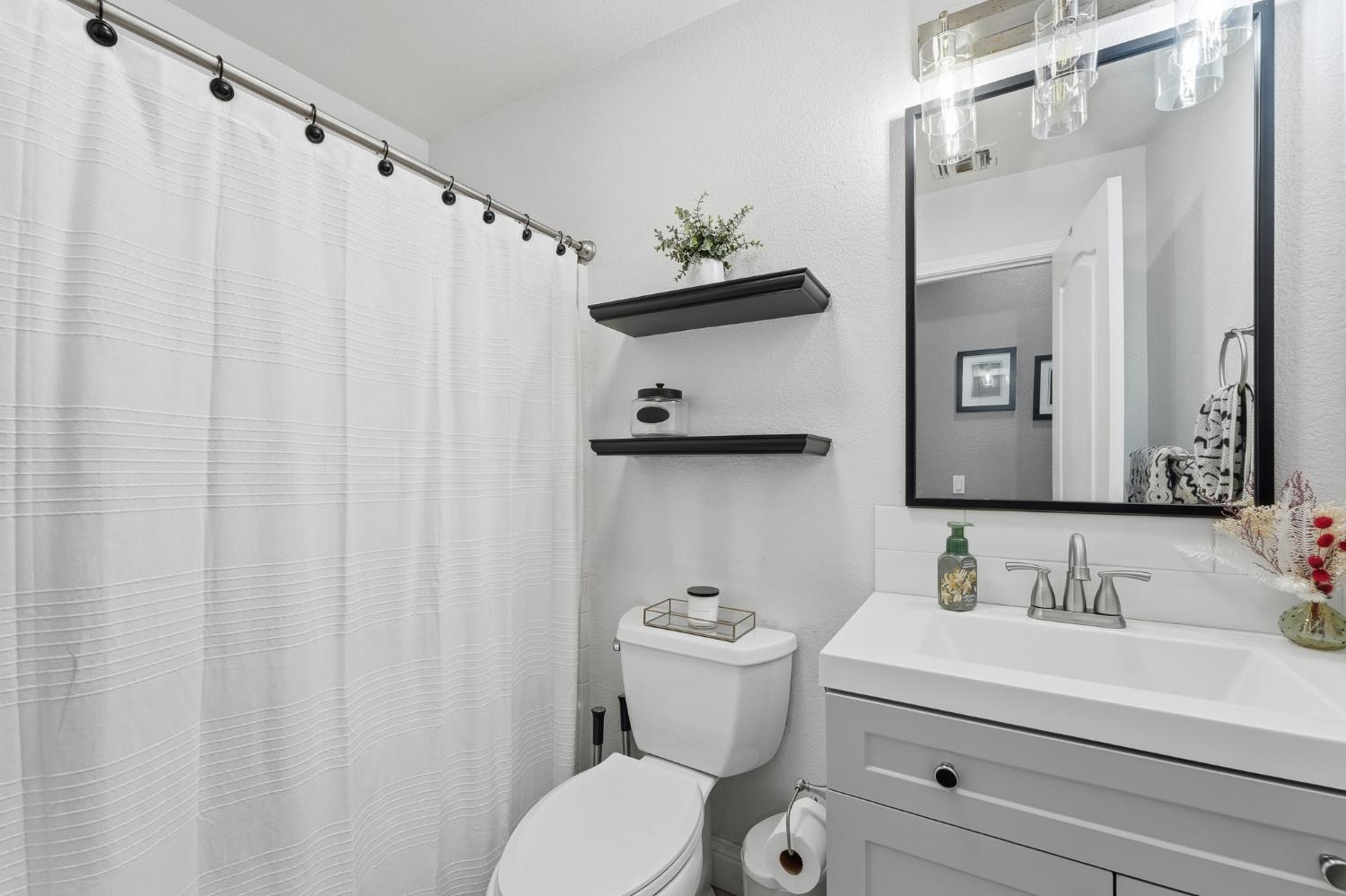 2220 Ellison Drive Modesto, CA 95355 - Photo 31 of 53 a bathroom with a sink vanity mirror and toilet