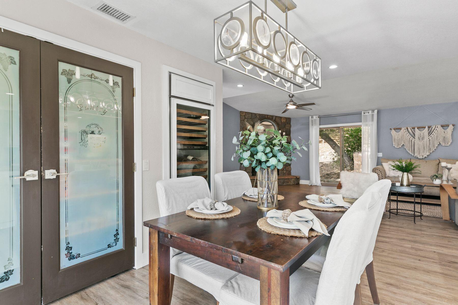 217 Sunset Street Oak View, CA 93022 - Photo 9 of 28 a dining room with wooden floor a chandelier a wooden table and chairs