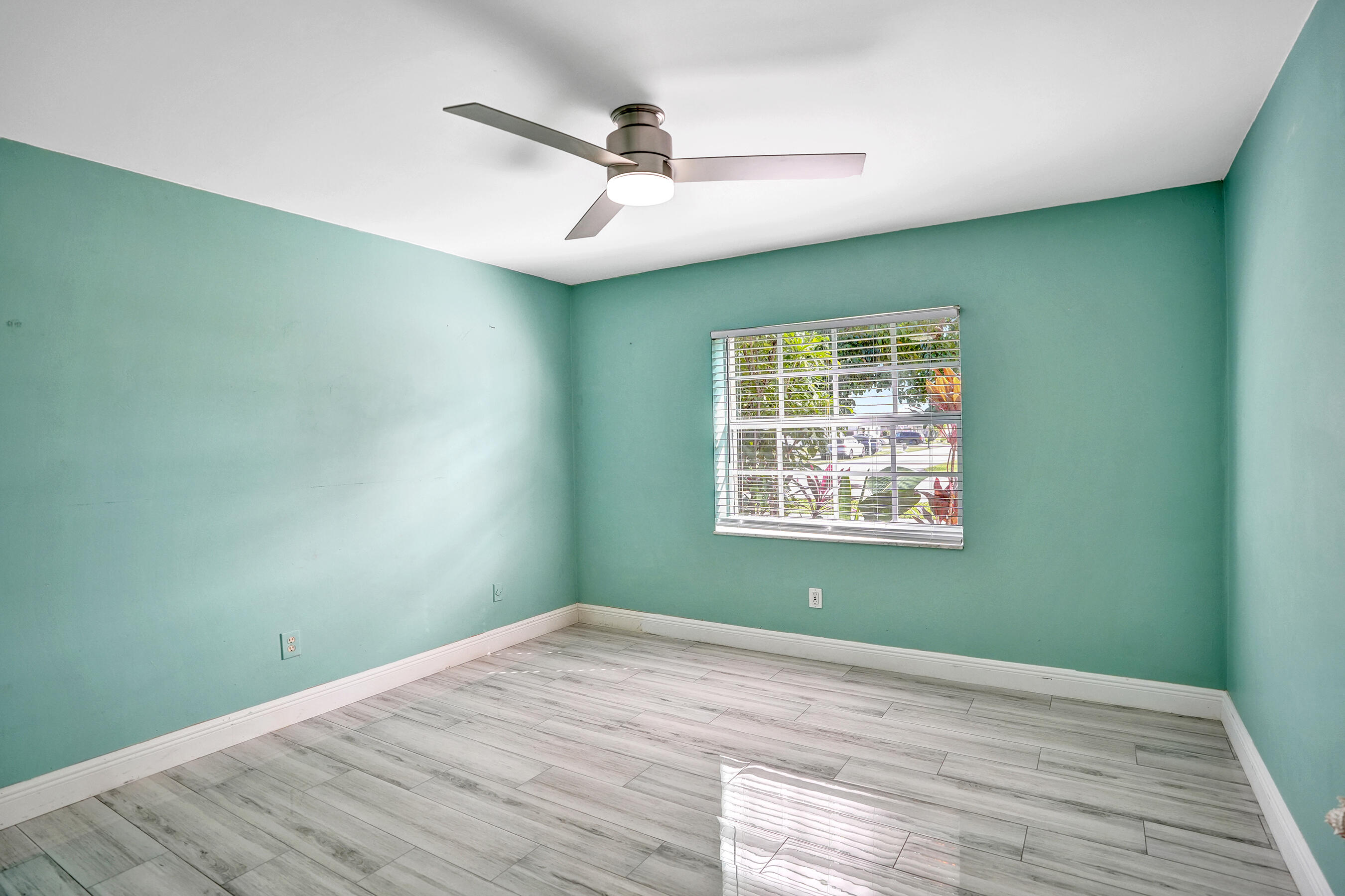 22335 Boulder Street Boca Raton, FL 33428 - Photo 14 of 36 en empty room with wooden floor ceiling fan and window