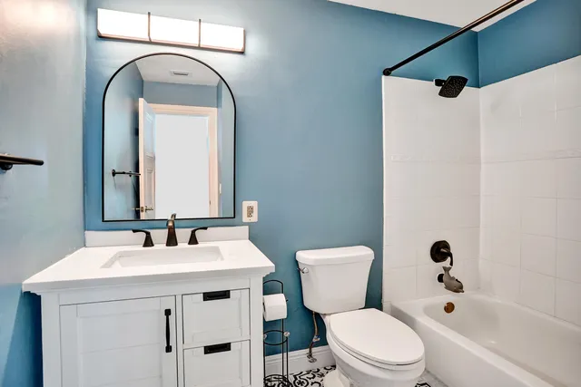 a bathroom with a sink mirror toilet and shower