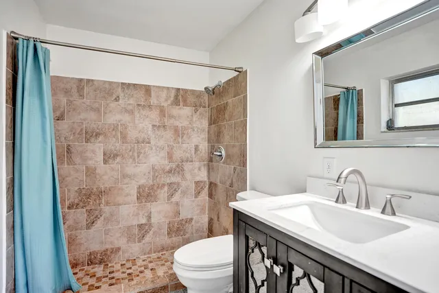 a bathroom with a sink a toilet and shower curtain