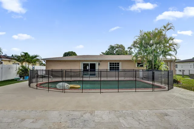 a view of a house with backyard and a tree