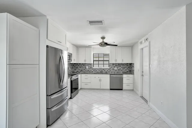 a kitchen with a refrigerator sink and cabinets
