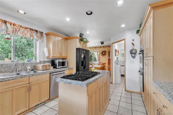 a kitchen with stainless steel appliances granite countertop a sink a stove and a microwave