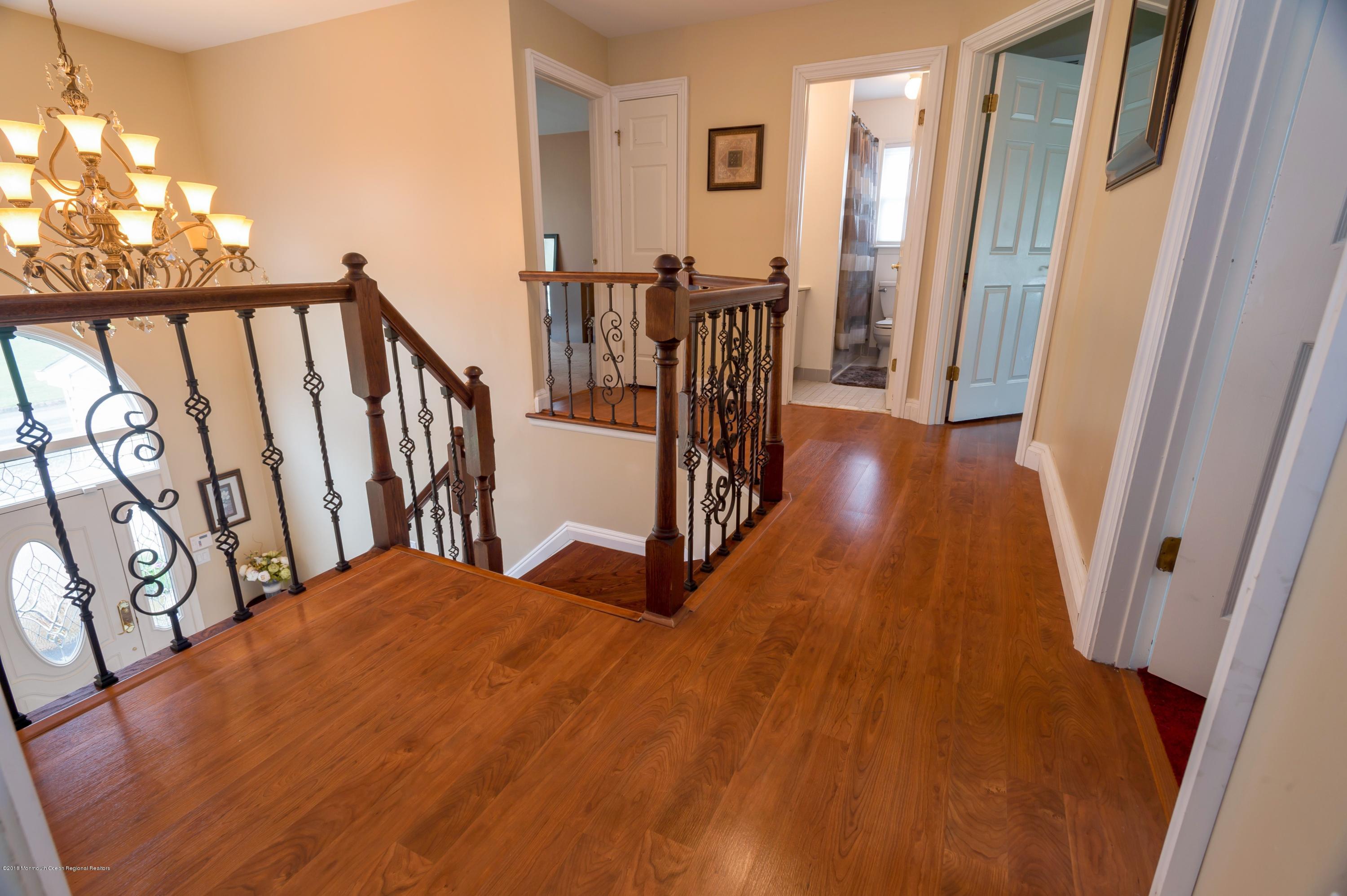 17 Walnut Court Matawan, NJ 07747 - Photo 11 of 17 a view of a hallway with wooden floor and stairs