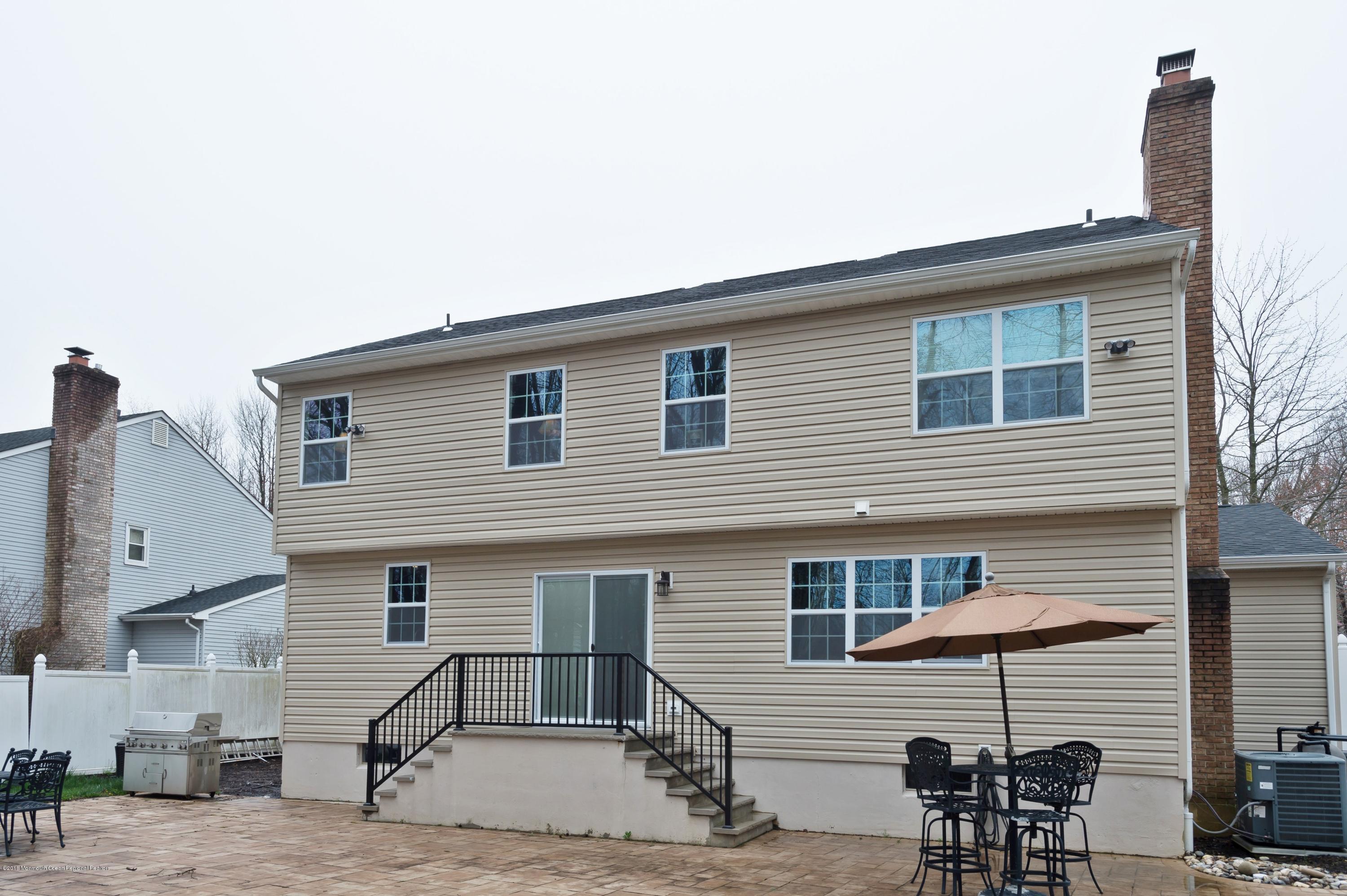 17 Walnut Court Matawan, NJ 07747 - Photo 16 of 17 a front view of a house with glass top table and chairs