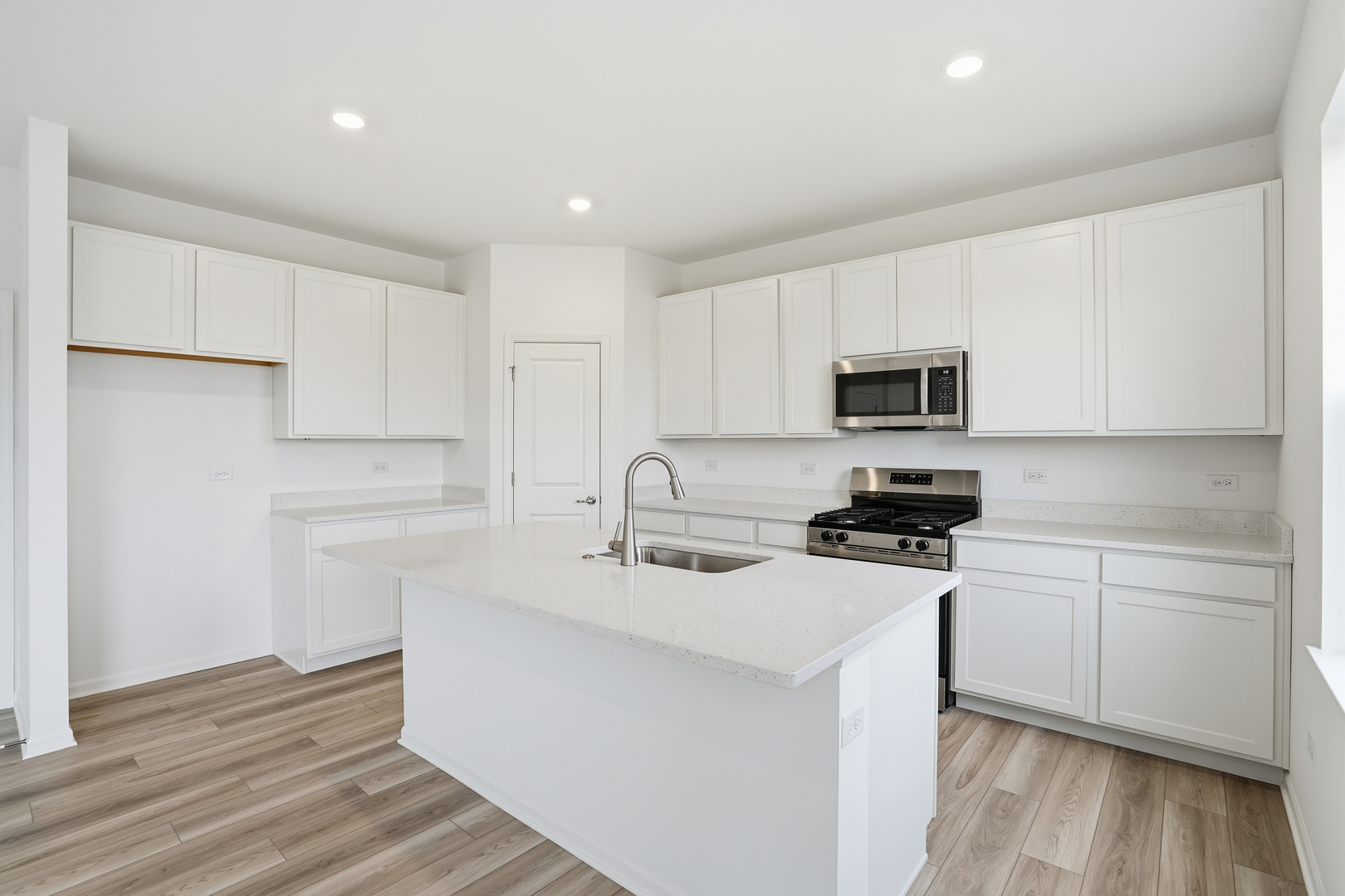 342 Danforth Drive Oswego, IL 60543 - Photo 8 of 21 a kitchen with stainless steel appliances a sink dishwasher a stove top oven a refrigerator with white cabinets and wooden floor
