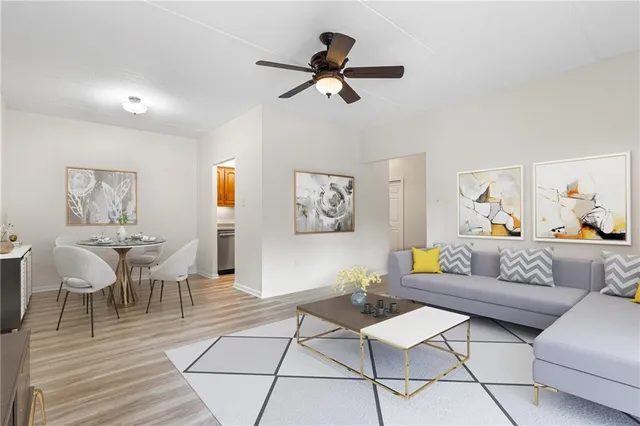 a view of a hallway with wooden floor and a ceiling fan