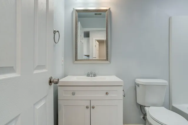 a bathroom with a toilet sink and mirror