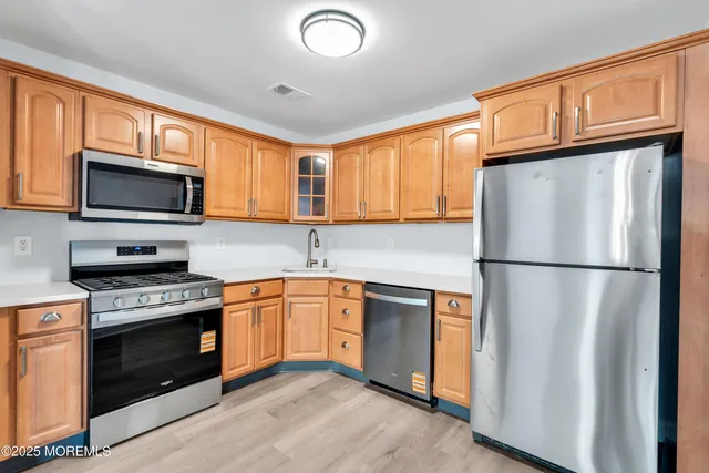 a kitchen with stainless steel appliances granite countertop a refrigerator stove a sink dishwasher and microwave
