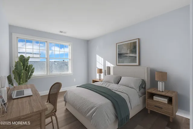 a bedroom with a bed table chair and window