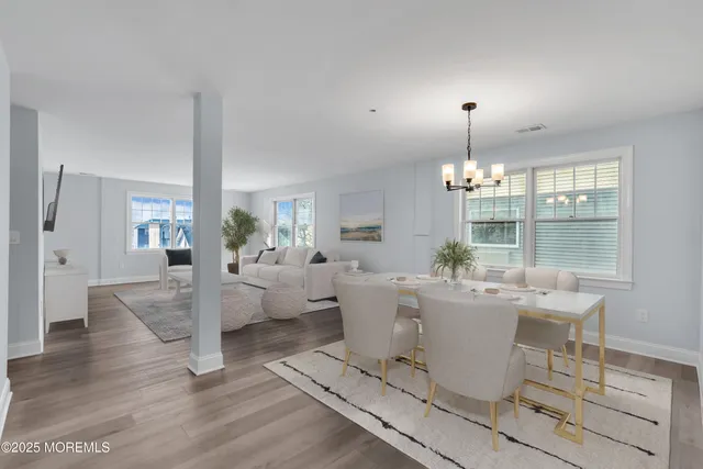a view of a dining room with furniture wooden floor and a chandelier