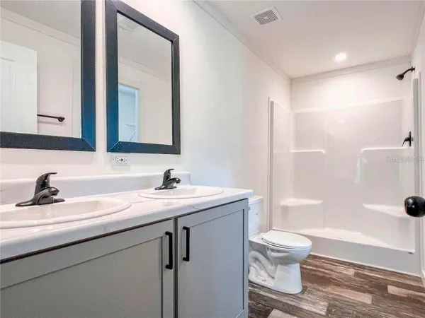 a bathroom with a granite countertop toilet sink and shower