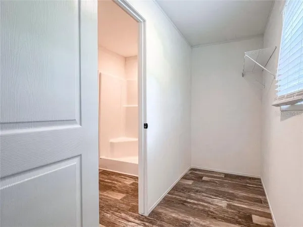 an empty room with a window and a fan