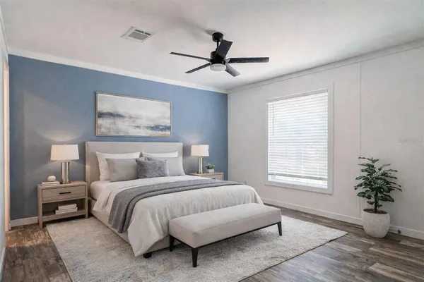 a view of empty room with wooden floor and fan