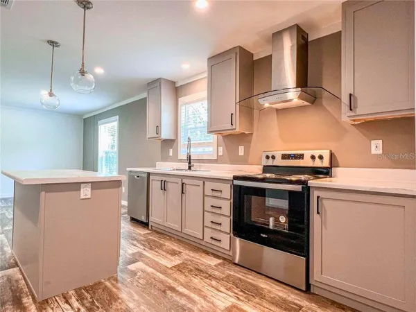 a kitchen with stainless steel appliances granite countertop a stove a sink and a refrigerator