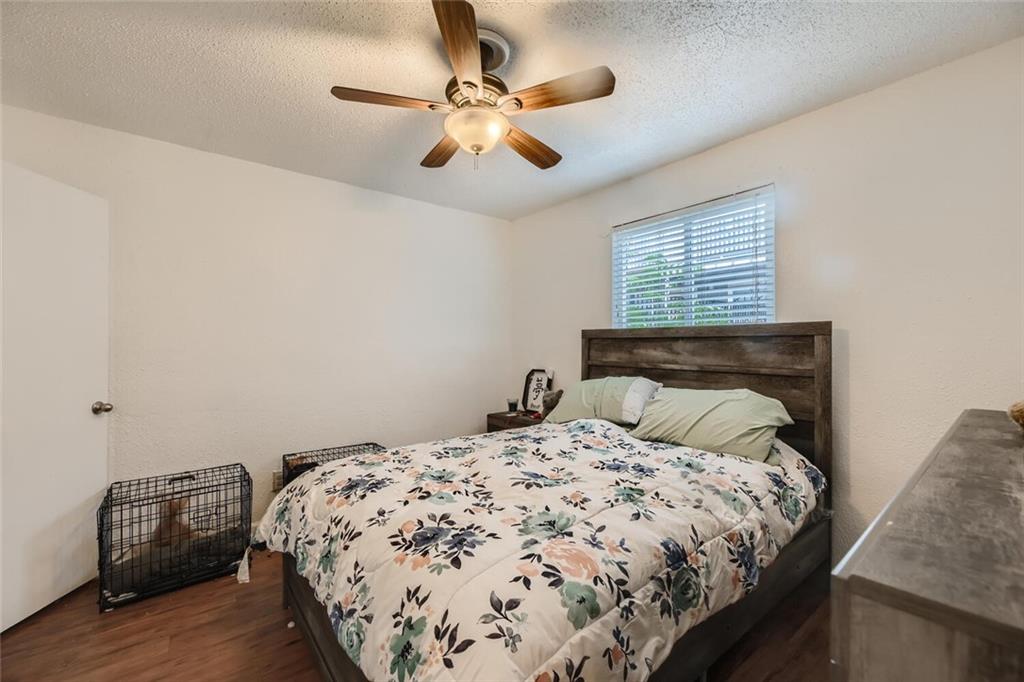 2401 Manor Road, Unit 111 Austin, TX 78722 - Photo 11 of 23 a bedroom with a bed and a ceiling fan