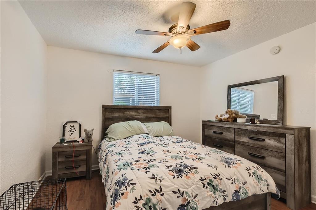 2401 Manor Road, Unit 111 Austin, TX 78722 - Photo 12 of 23 a bedroom with a bed and wooden floor
